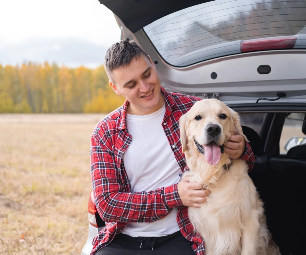 Pet owner with Golden Retriever at the back of a car during pet transport pickup
